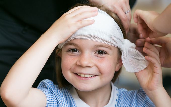 School child with bandage around head