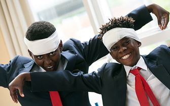 Two school children learning how to bandage head