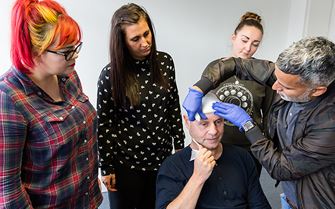First aid course participants applying a head bandage