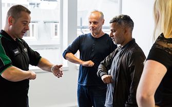 St John Ambulance first aid trainer demonstrating the correct technique for the Heimlich Manoeuvre
