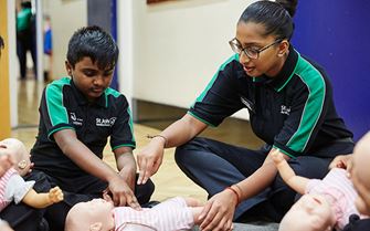 Youth Team Helper teaching CPR to Badger